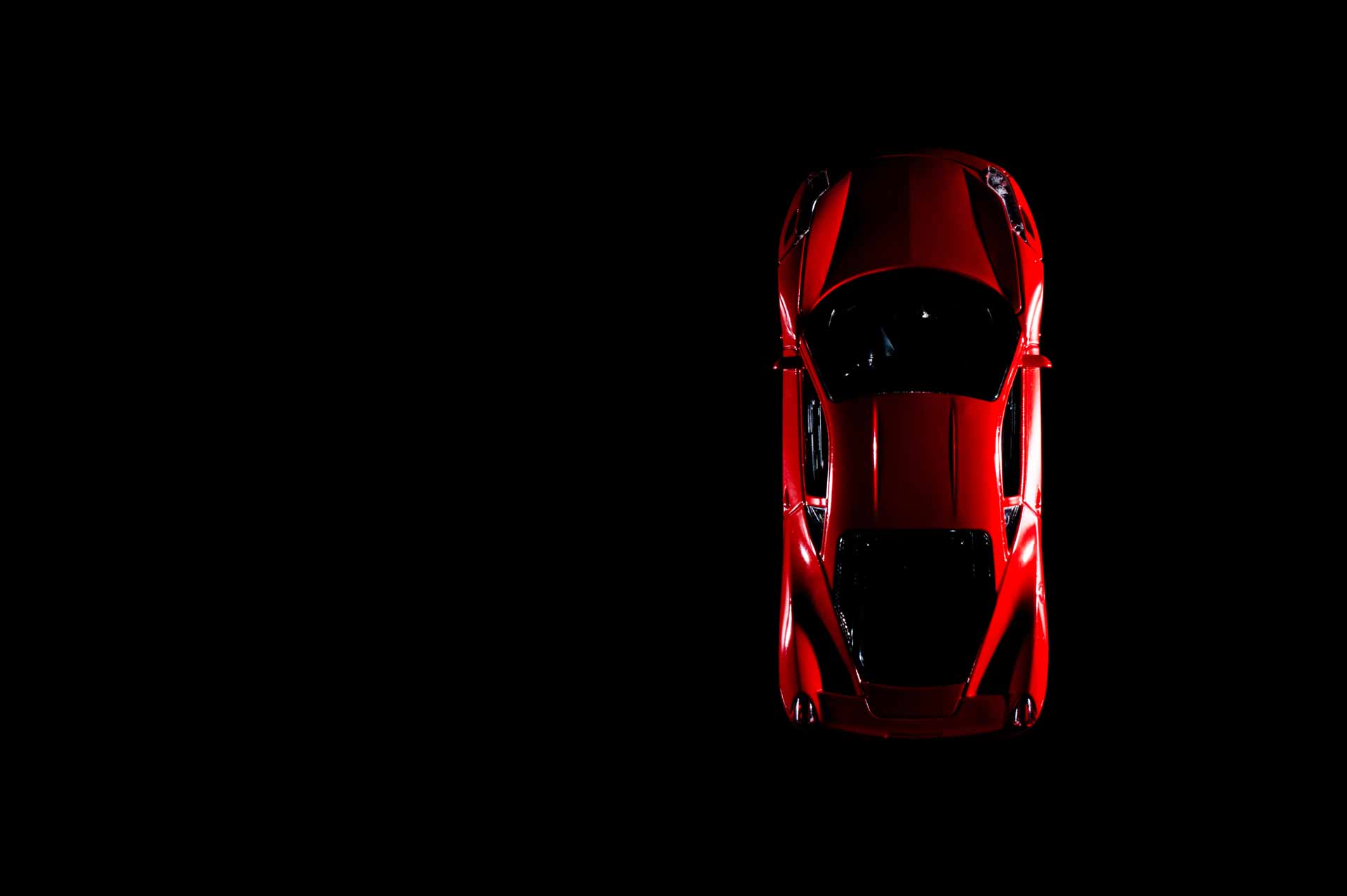 Top angle of red sports car in dark room